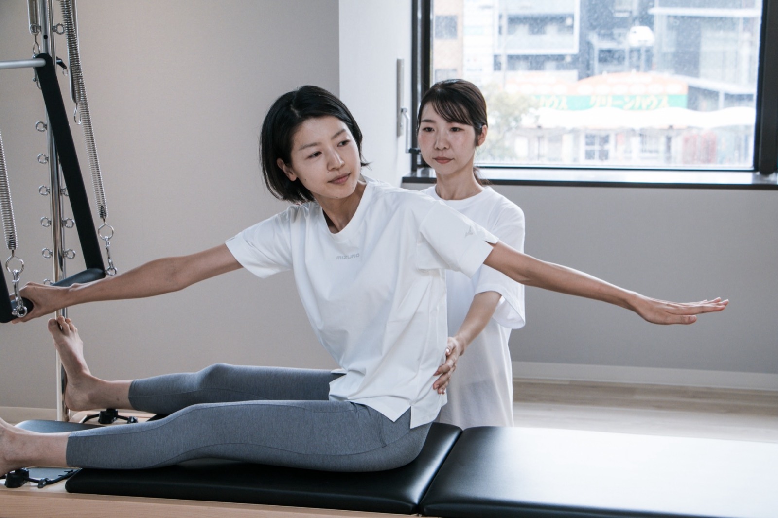 トレーナーが姿勢を確認しながら支える様子